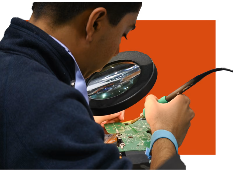 Student soldering a printed circuit board