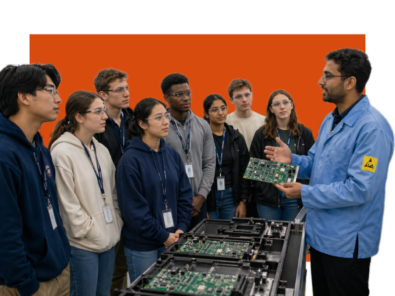 Worker holding circuit board showing students