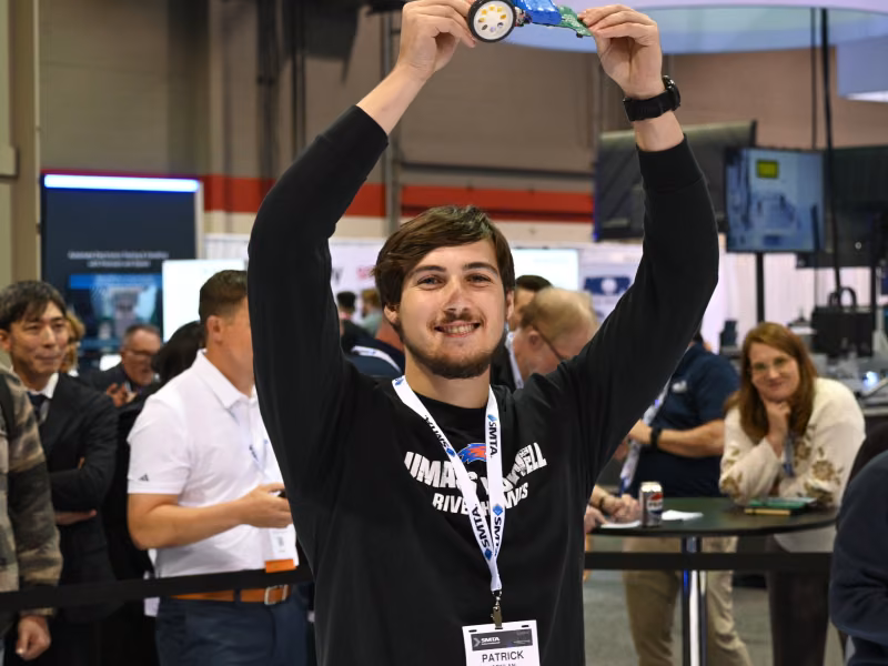 Student holding robotic car in the air