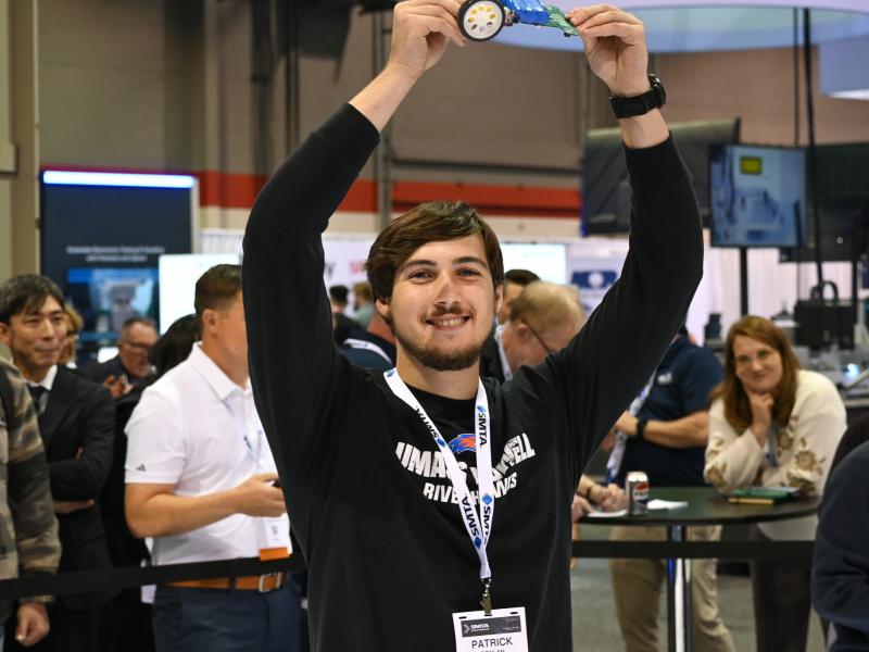 Student holding robotic car in the air