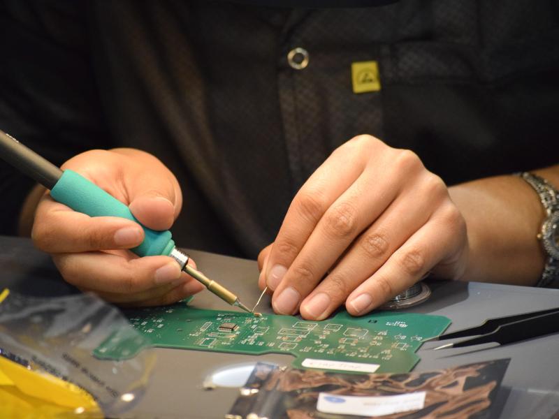 Hands soldering a printed circuit board