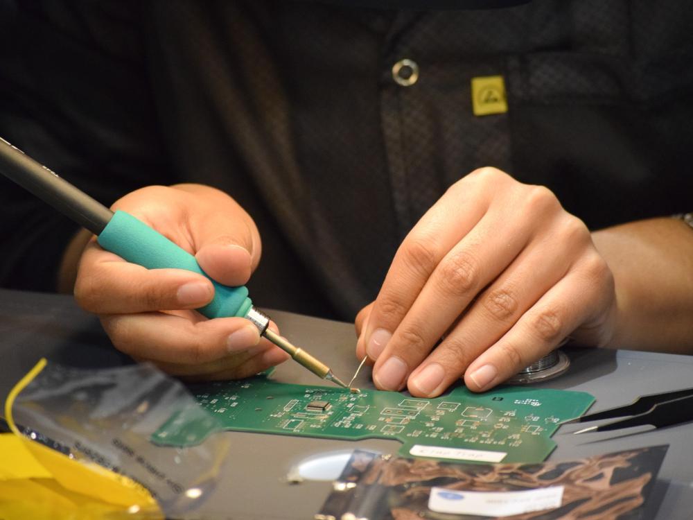 Hands soldering a printed circuit board